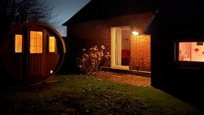 Een huis met een bakstenen gevel, een houten deur en een raam met gordijn.