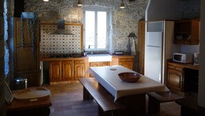 Una cocina rústica con armarios de madera, una pared de piedra y un amplio ventanal.