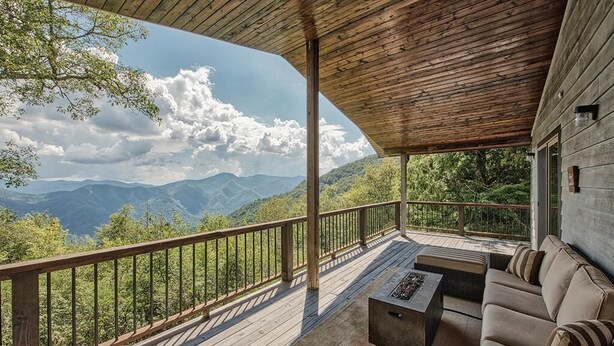 Una terrazza coperta con tetto in legno, un divano e un braciere.