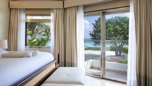 Une chambre d’hôtel avec un lit, un banc et de grandes fenêtres avec des rideaux.