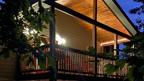 A two-story wooden house with a balcony, a front door, and a window. - Bear Pause, a perfect family vacation home, minutes from attractions! (Pigeon Forge)