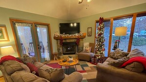 A cozy living room with two sofas, a fireplace, a TV, and a Christmas tree. - Bear Pause, a perfect family vacation home, minutes from attractions! (Pigeon Forge)