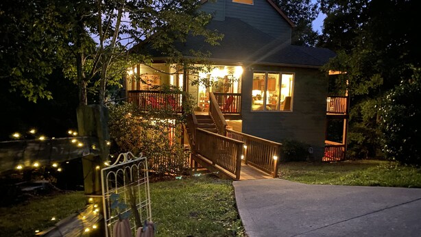 A house with a porch, a staircase, and string lights. - Bear Pause, a perfect family vacation home, minutes from attractions! (Pigeon Forge)