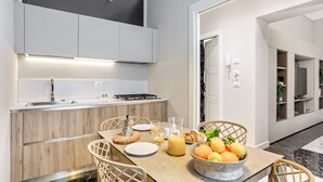 Een moderne keuken met een eethoek, compleet met een ontbijtpresentatie met fruit en gebak.
