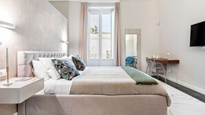 Een moderne slaapkamer met een groot bed, een bureau en een televisie.