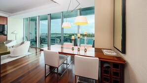 A modern dining area with a wooden table, white chairs, and pendant lights.
