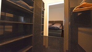 Ein Schlafzimmer mit Bett, Spiegel und Kleiderschrank.
