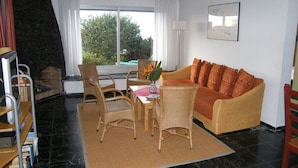 Una sala de estar acogedora con sofá, sillones, una mesa y chimenea.