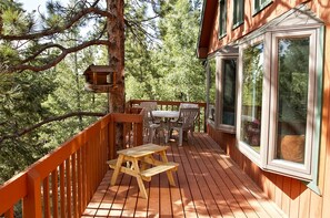 Enjoy dining or socializing on the deck overlooking a dense forest.