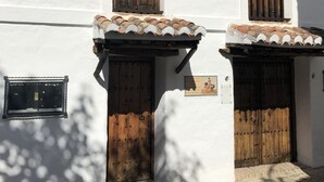 Un bâtiment traditionnel aux murs blancs, aux portes en bois et aux toits couverts de tuiles.