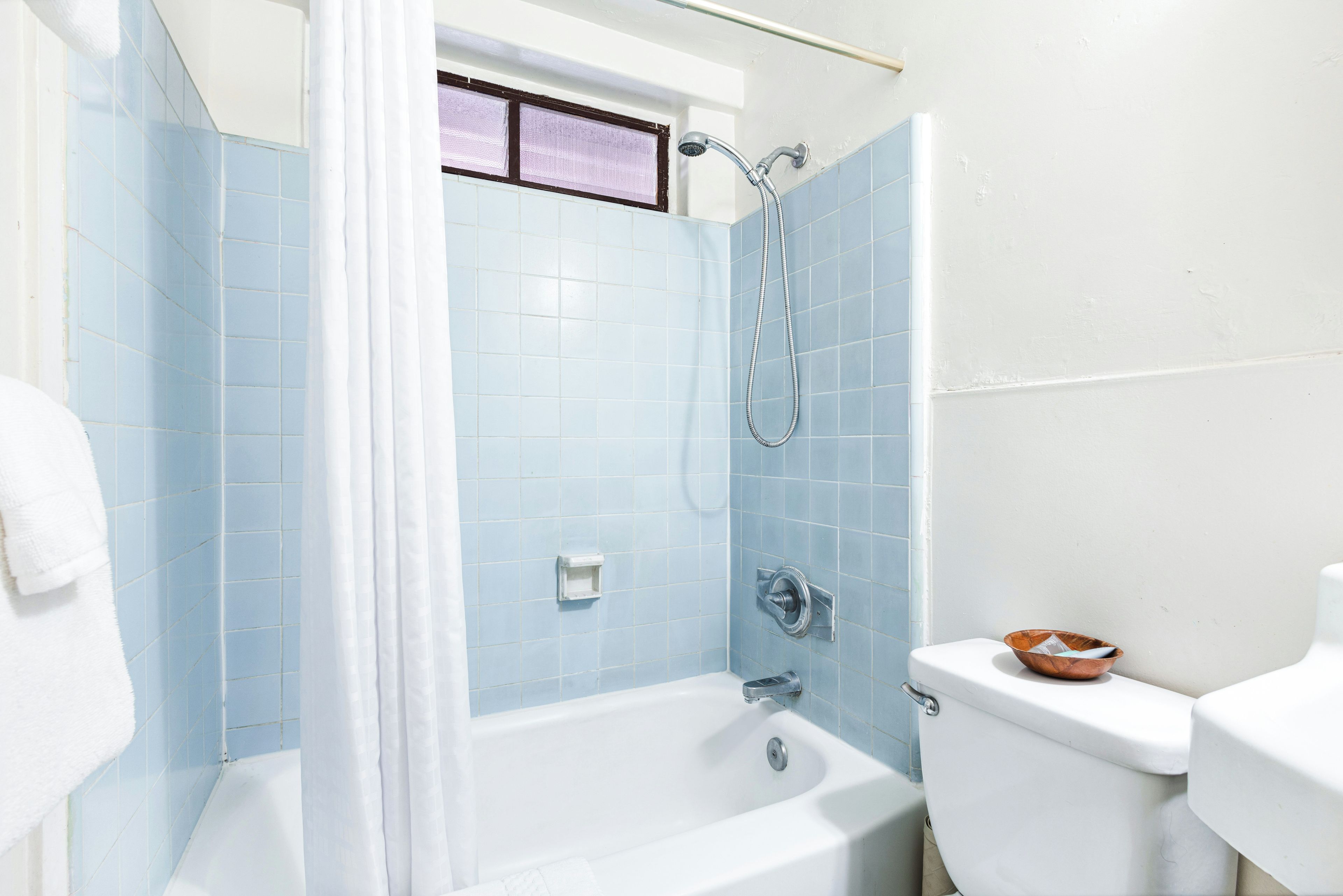 A bathroom with a bathtub, toilet, and shower.