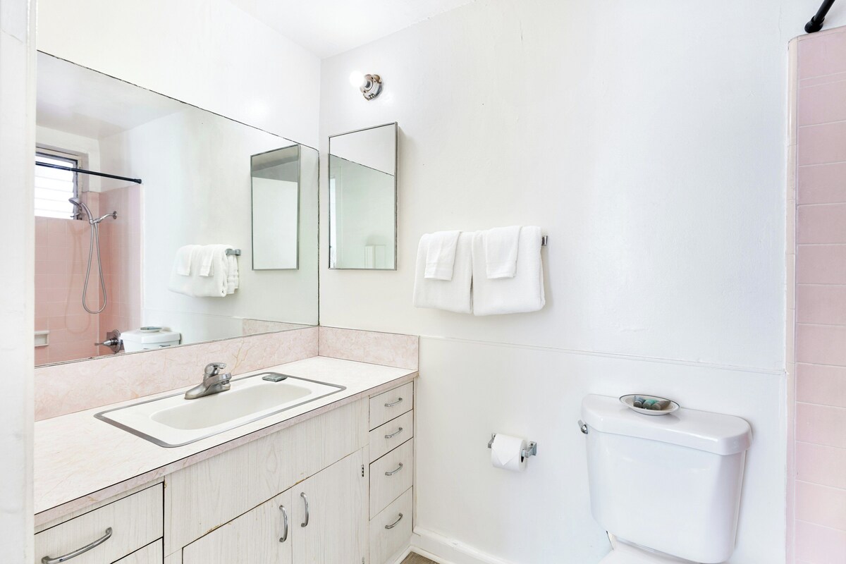 A bathroom with a sink, mirror, toilet, and towel rack.