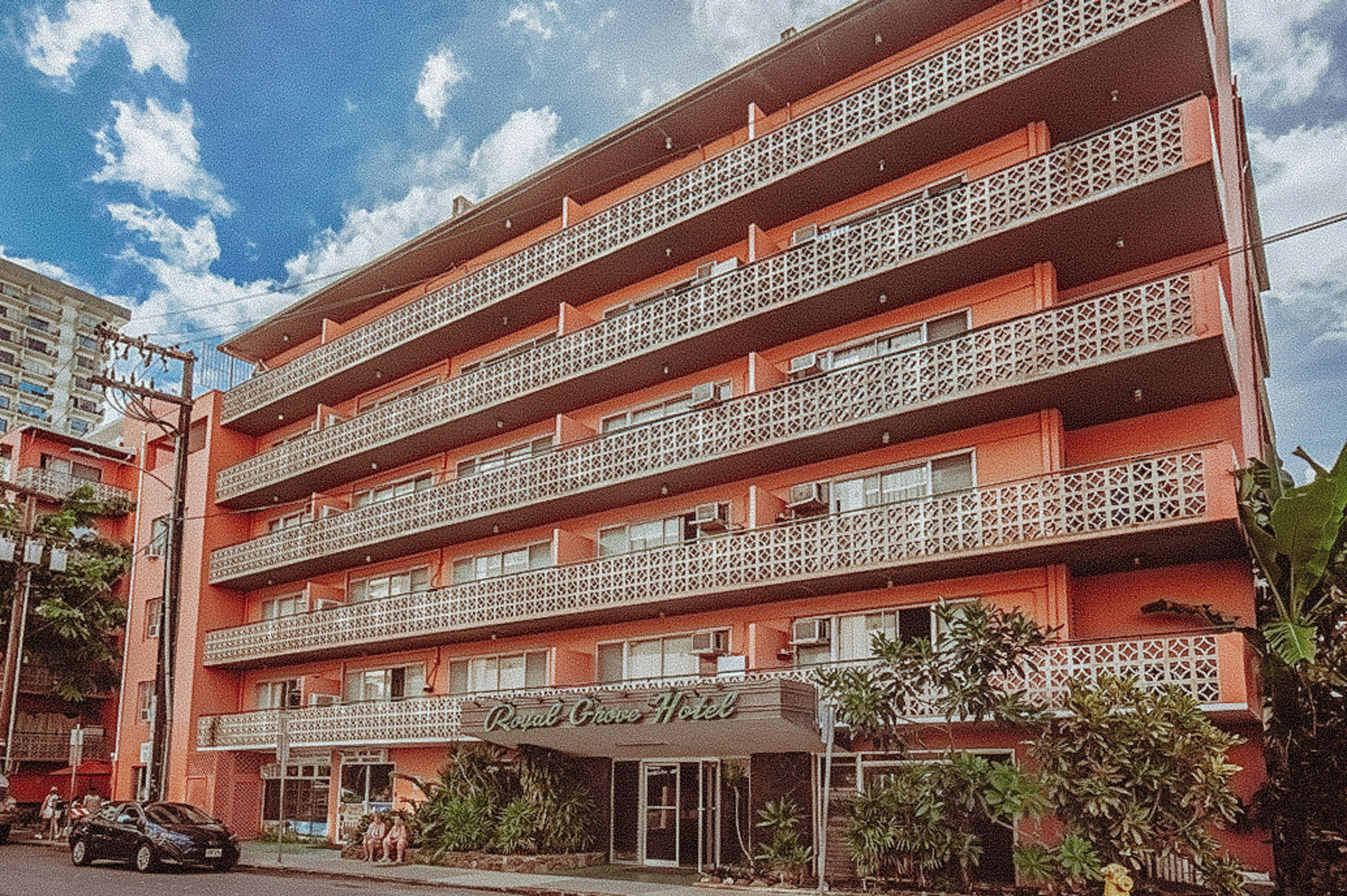 A multi-story hotel with balconies and a sign reading 'Royal Grove Hotel.'