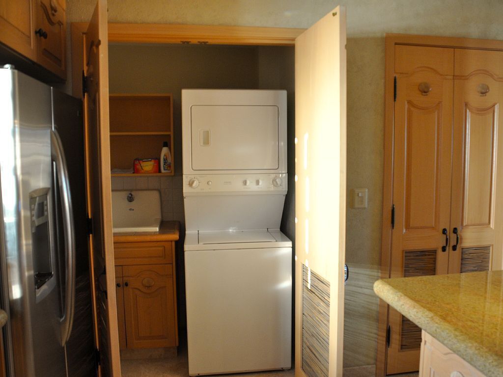 A compact kitchen with a refrigerator, a microwave, and a built-in oven.