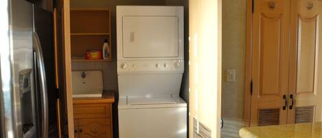 A compact kitchen with a refrigerator, a microwave, and a built-in oven.