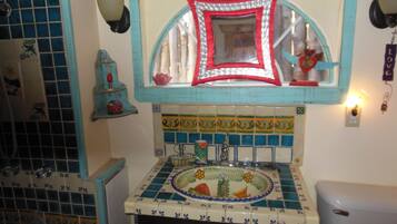 A bathroom with a sink, mirror, and decorative tiles.