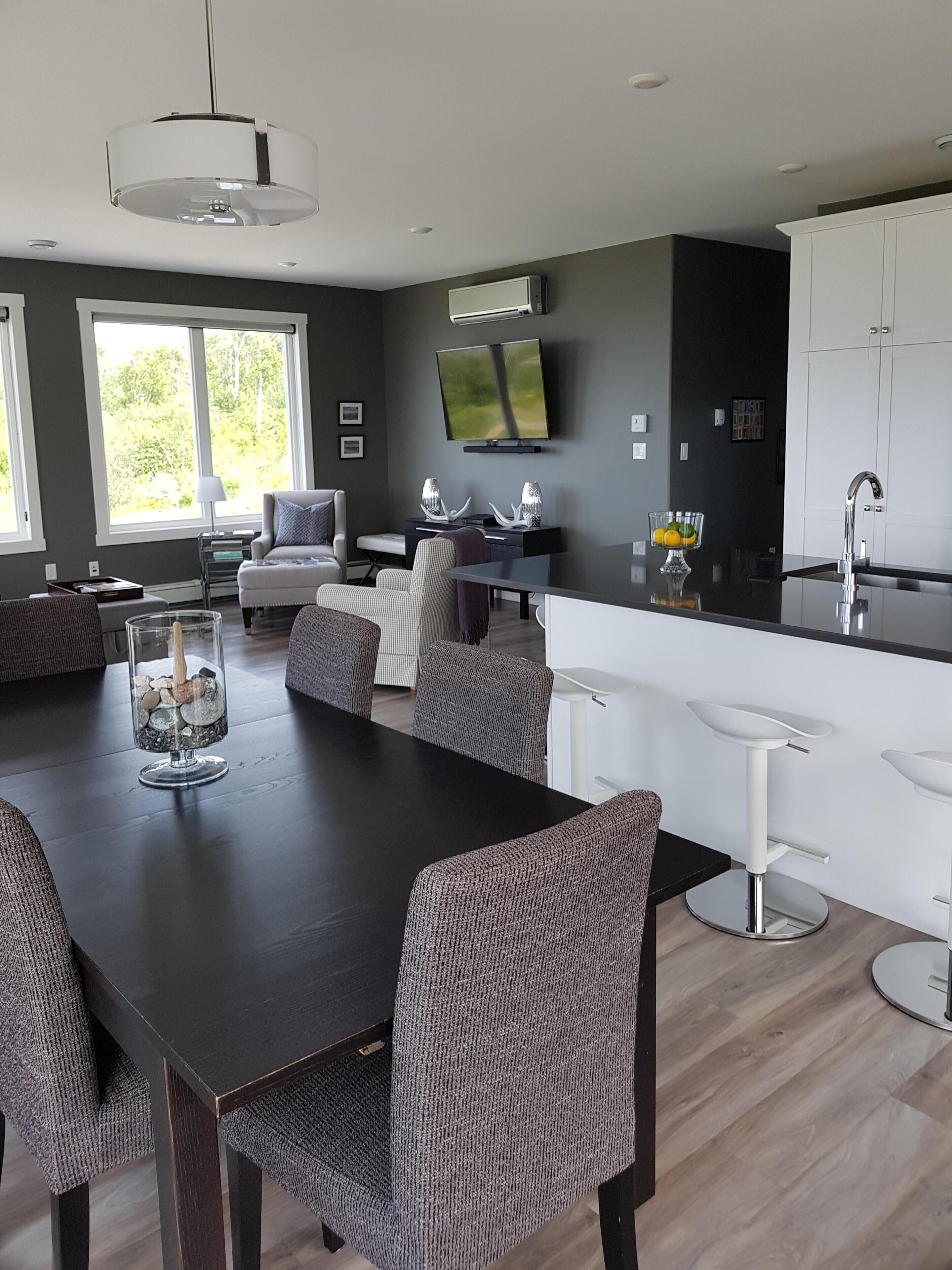 Una cocina moderna con comedor, ventanas amplias y un televisor de pantalla plana.
