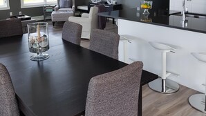 Une cuisine moderne avec un coin repas, de grandes fenêtres et un téléviseur à écran plat.