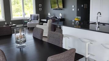 Una cocina moderna con comedor, ventanas amplias y un televisor de pantalla plana.