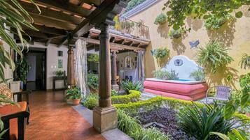 A courtyard with a fountain, potted plants, and a seating area.