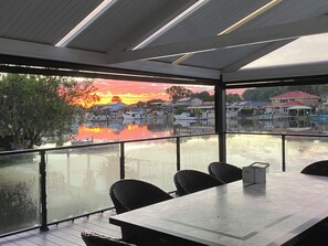 A restaurant with a view of a waterfront and sunset.