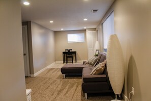 Cozy living room with a brown sectional sofa, small table, and floor lamp.