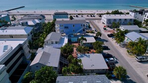A coastal town with buildings, a beach, and a pier. - Bright Coastal Unit Steps From Beach/Walk 2 Bridge (bradenton beach)