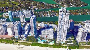 A high-rise hotel complex with multiple buildings, a beachfront, and a marina.