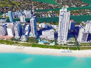 A high-rise hotel complex with multiple buildings, a beachfront, and a marina.