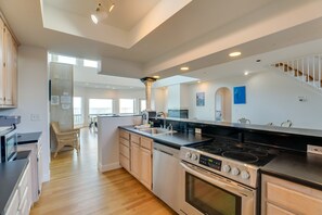 A modern kitchen with a central island, stainless steel appliances, and a view to the living area. - OCEANFRONT/BEACHFRONT- 7 Bedroom House!
One block from Restaurants and Shops!!! (isle of palms)