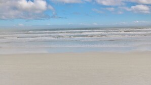 Une plage aux vastes rivages sablonneux et aux vagues douces.