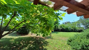 A wooden pergola structure with a view of a grassy area and trees. - Peaceful house with lots of privacy near Umag. Sea view. (Buje)
