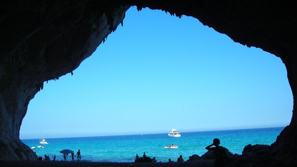 A cave opening to a beach with a clear view of the sea and boats. - MarVy house (Arbatax)