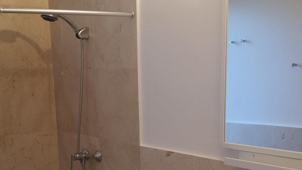 Une salle de bain avec douche, toilettes et lavabo.