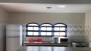 A kitchen with a refrigerator, microwave, toaster, and stove. - Casa De Praia Anequim (Cabo Frio)