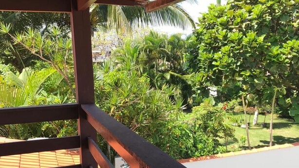 A covered outdoor area with a tiled floor and a wooden railing. - Casa De Praia Anequim (Cabo Frio)