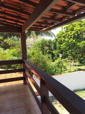 A covered outdoor area with a tiled floor and a wooden railing. - Casa De Praia Anequim (Cabo Frio)