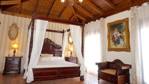Un letto a baldacchino con tenda, testiera in legno e lampadario.