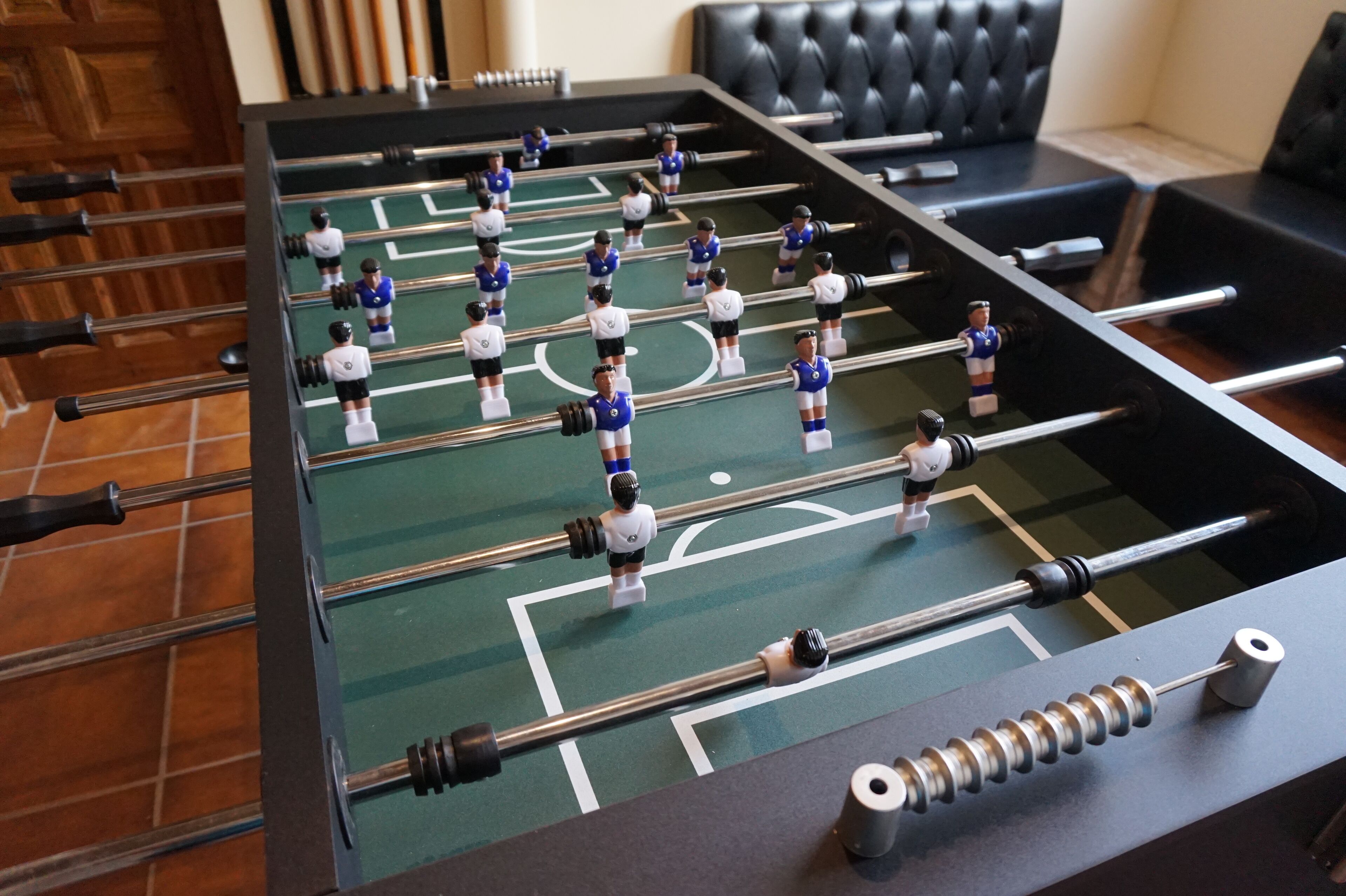 Ein Kicker mit grüner Spielfläche und schwarzen Ruten.