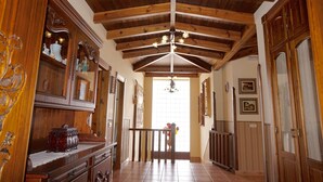Un corridoio con soffitti in legno, armadi decorati e un lampadario.