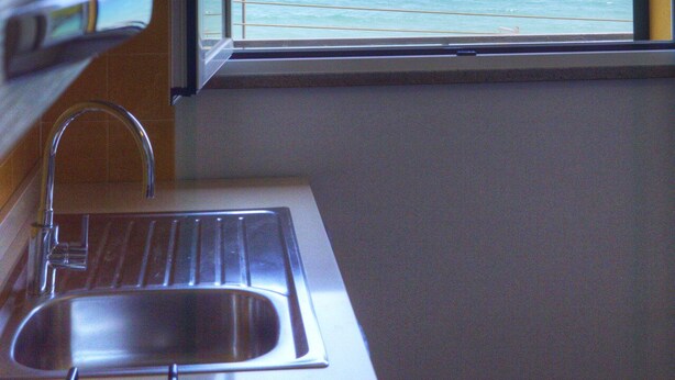 Una cucina con lavello e finestra vista mare.