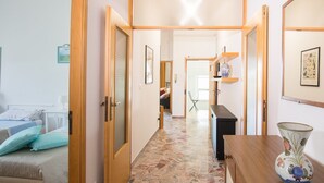 A hallway with a bed, a desk, and a vase. - Large and bright, a stone's throw from the castle, balcony, FREE WIFI, A / C, parking space (Rimini)