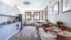 Una cocina moderna con encimeras de granito, electrodomésticos de acero inoxidable y un comedor con mesa lista para el desayuno.