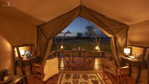 Una carpa con comedor, muebles de madera y vistas del paisaje.