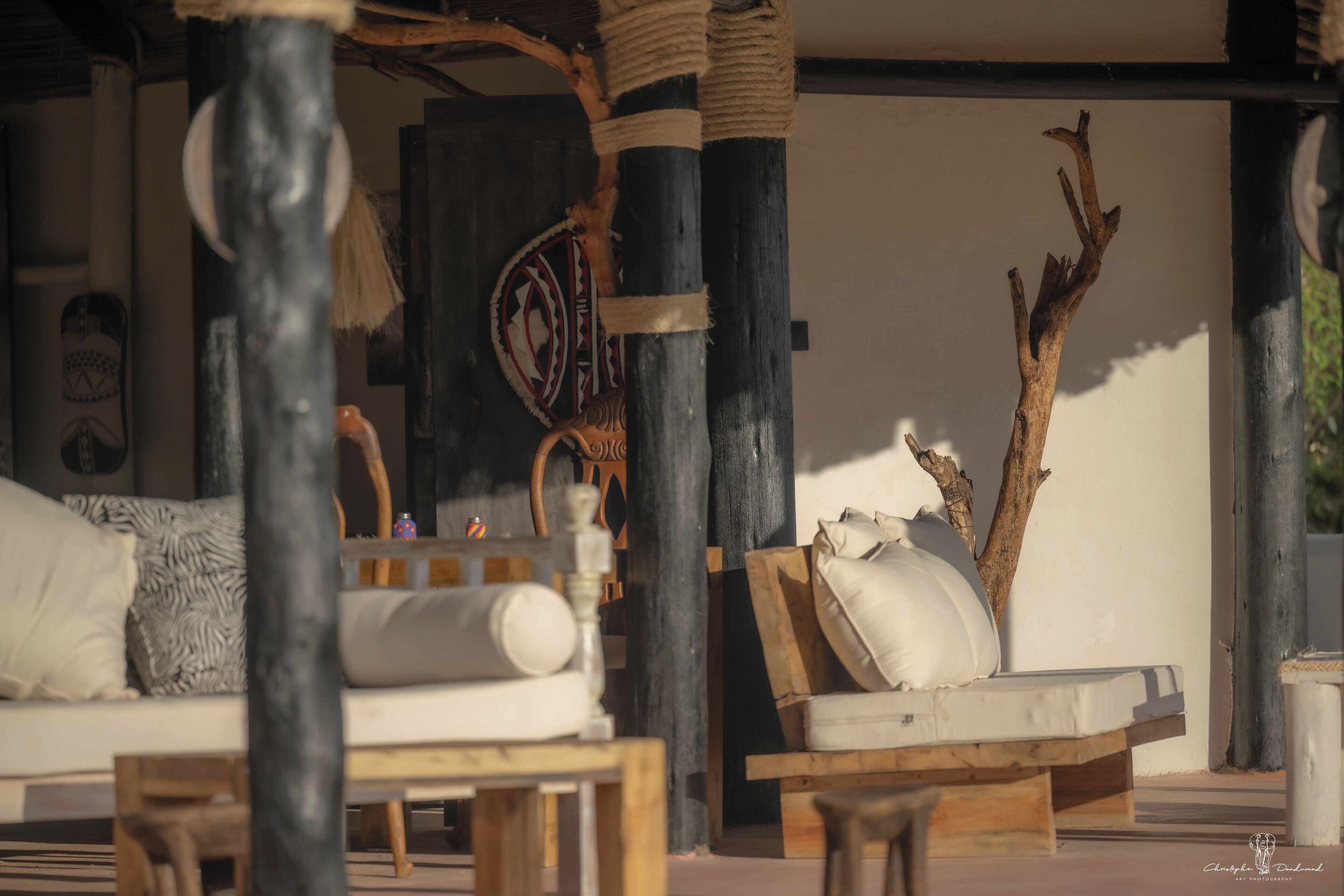 Un espacio al aire libre acogedor con mobiliario de madera y un muro decorativo.