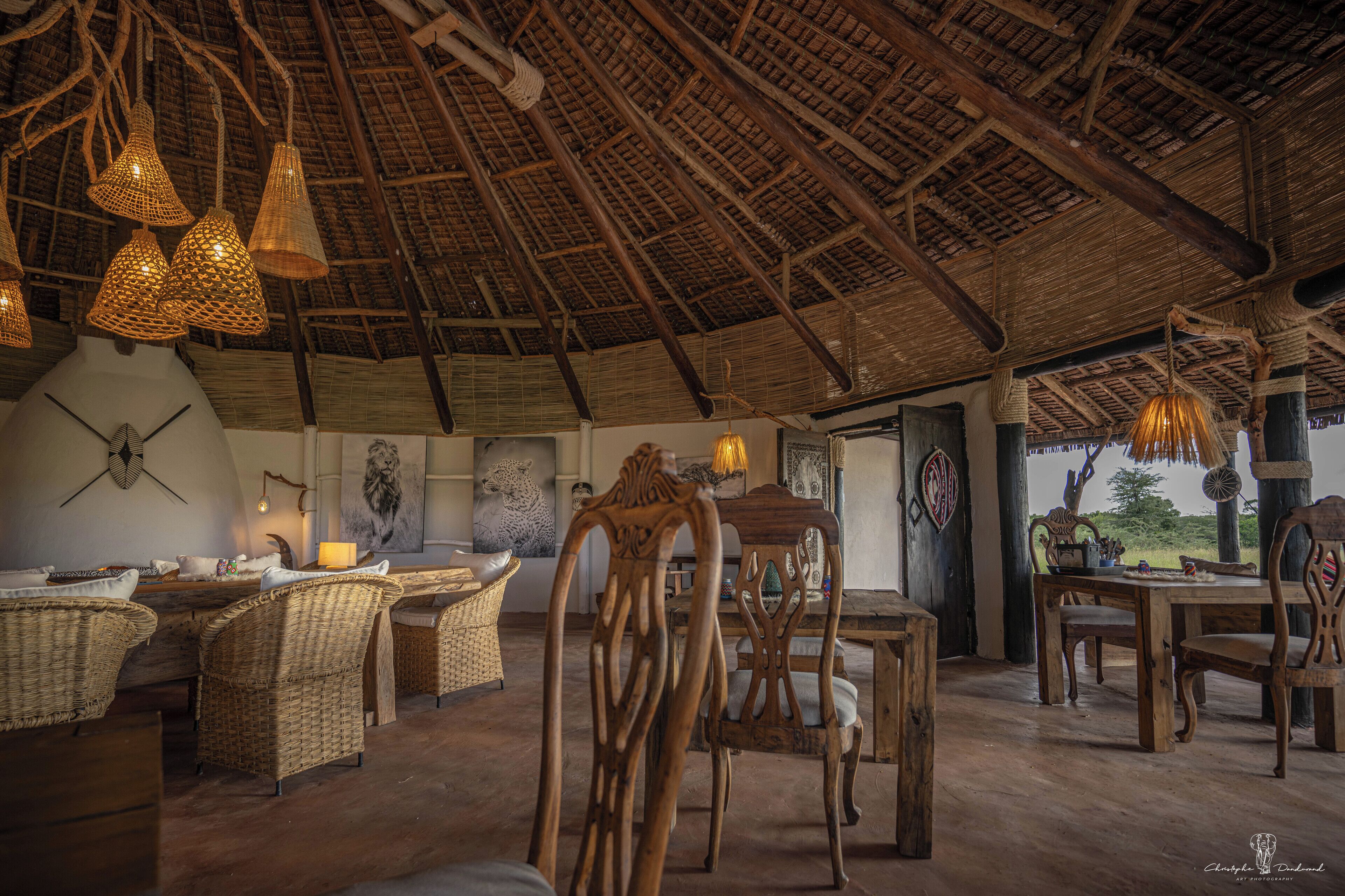 Een interieur met een rieten dak, rieten meubels en hanglampen.