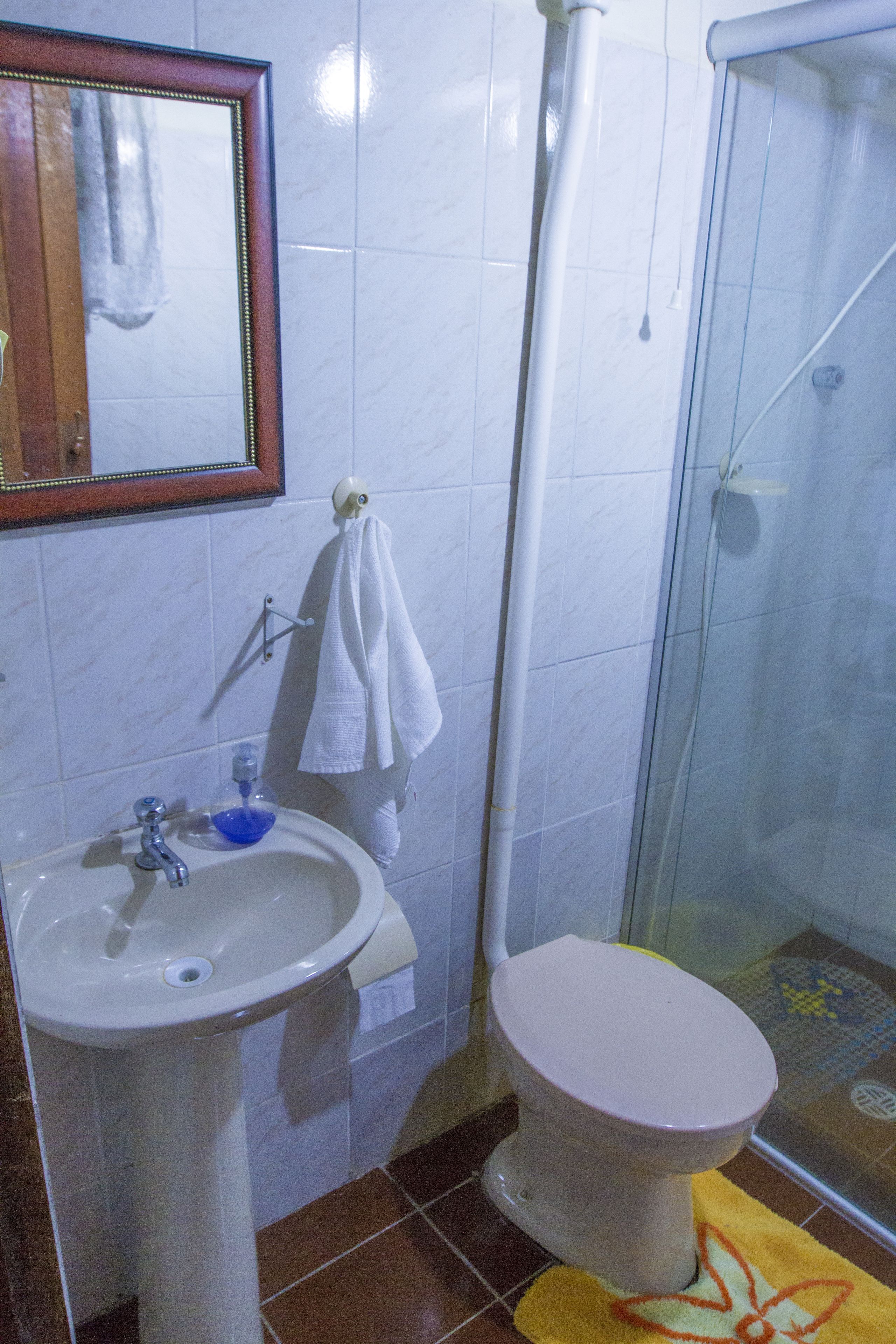 Un baño con lavabo, inodoro y cabina de ducha de vidrio.