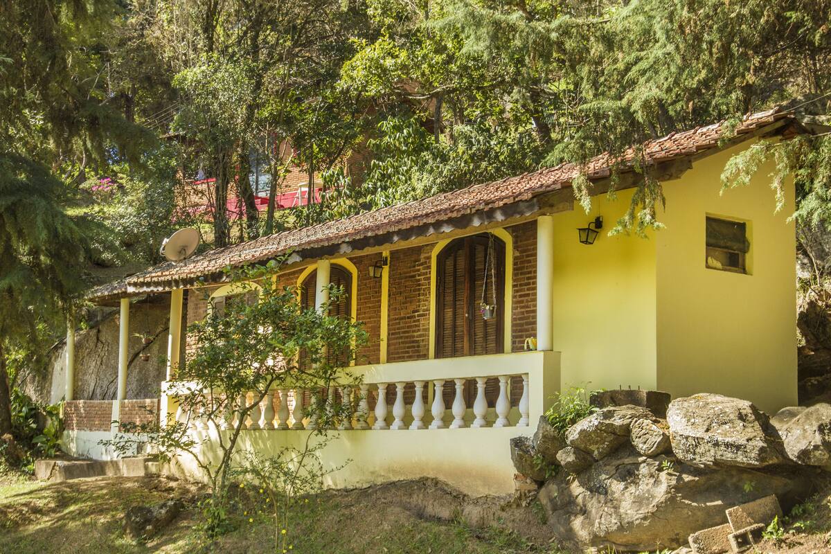A yellow building with a tiled roof, a balcony, and a satellite dish.