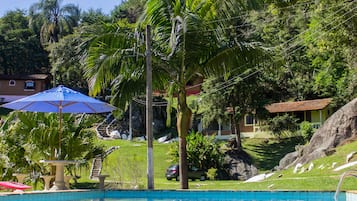 Una piscina al aire libre, sillones reclinables de piscina