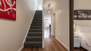 Staircase leads to an upper level with a comfortable bed and a unique artwork.